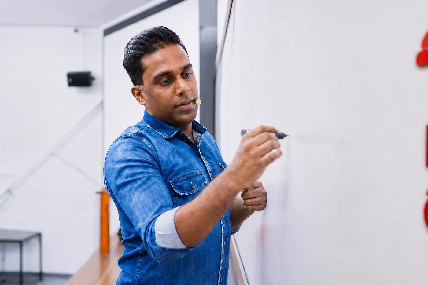 සුජිත් ලියනගේ පන්තියේ සුදු පුවරුව මත ලියමින් භෞතික විද්යාව උගන්වමින්