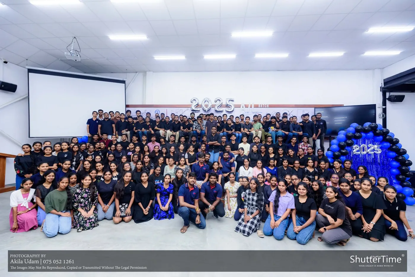 2025 බැලූන් අකුරු අසල සම්පූර්ණ කණ්ඩායමේ ඡායාරූපයක්