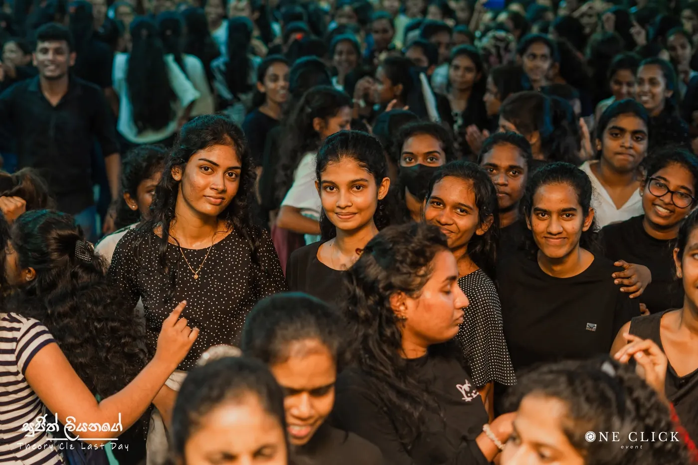 සිනාසෙන සිසුවියන් සහ සිසුන් සමූහයක්, කැමරාව දෙස බලා