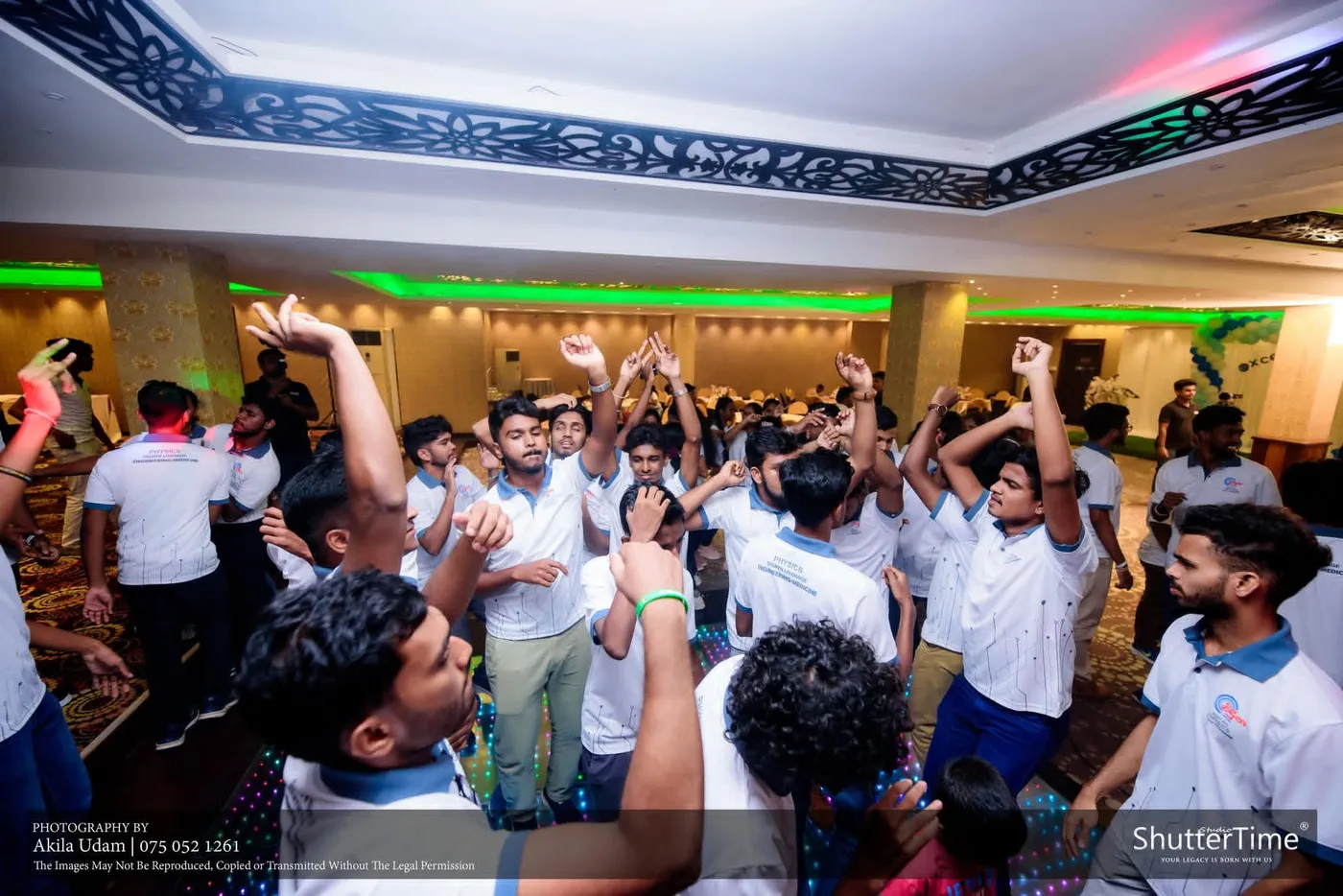සුදු කමිස ඇඳි සිසුන් සමූහයක් අත් ඔසවා