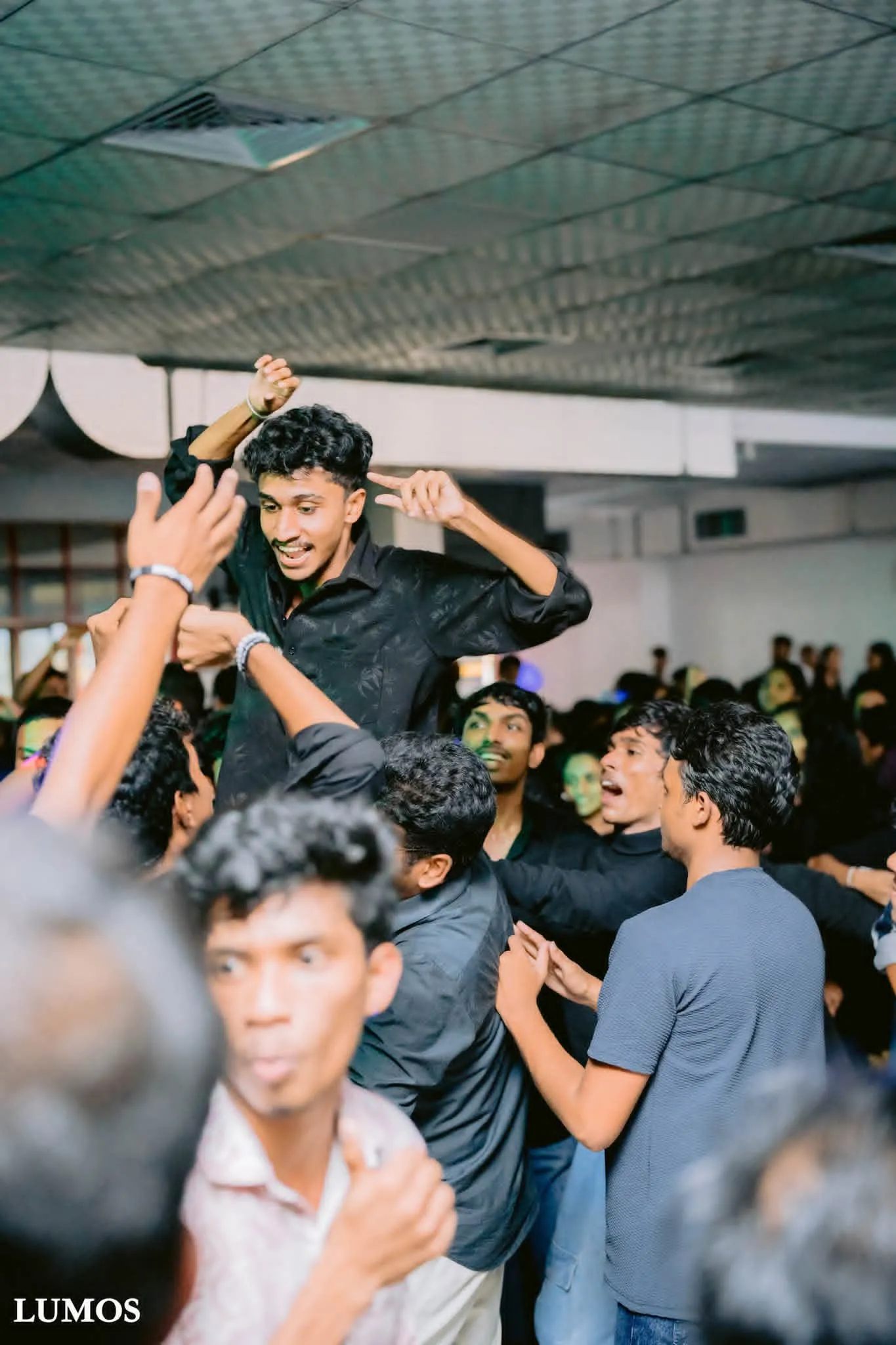 සිසුවෙක් අනෙක් අයගේ උරහිස් මත ඔසවා, දෑත් ඉහළට