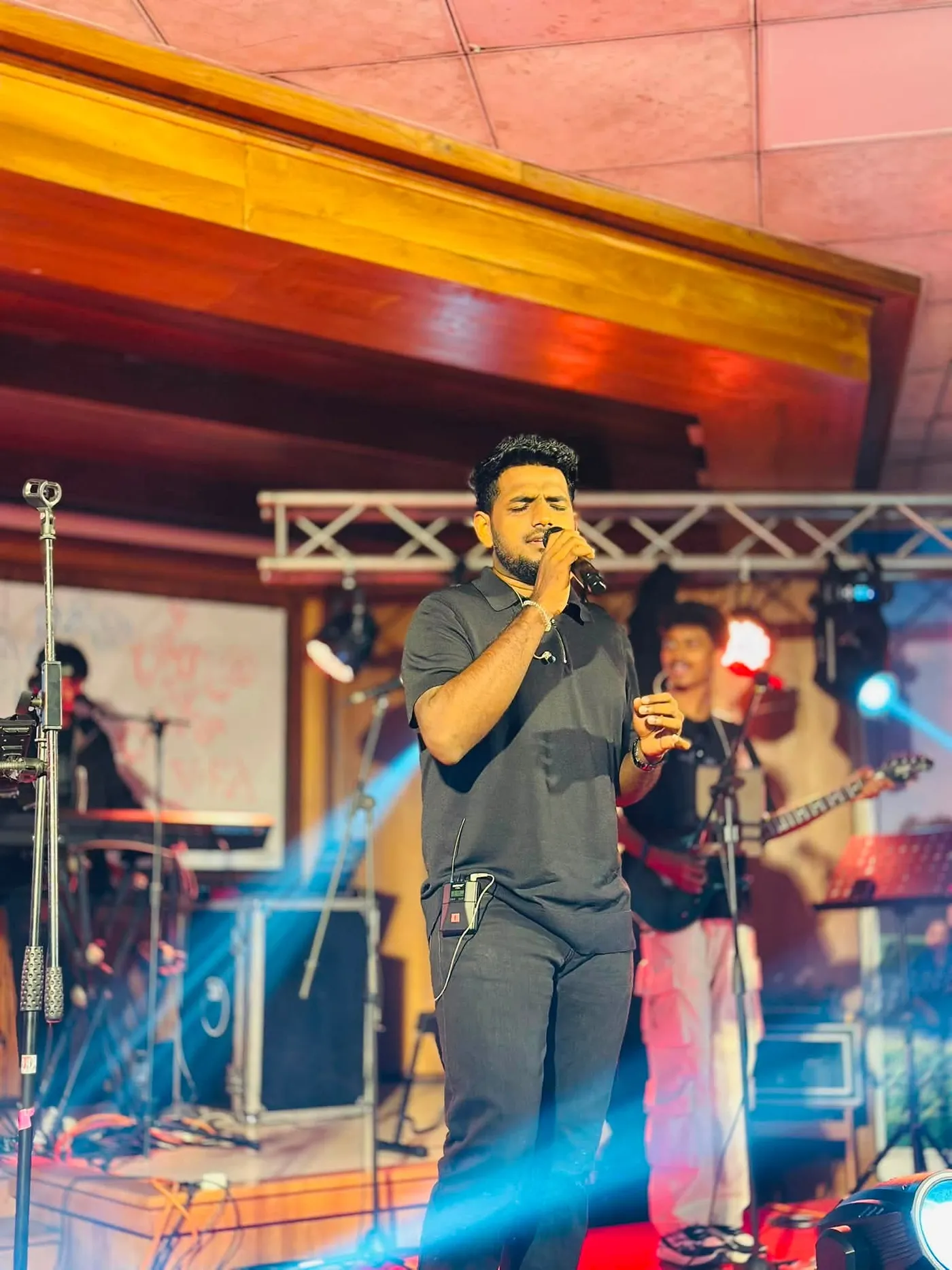 සංගීත කණ්ඩායමක් සමඟ වේදිකාවේ ගී ගයන අයෙක්