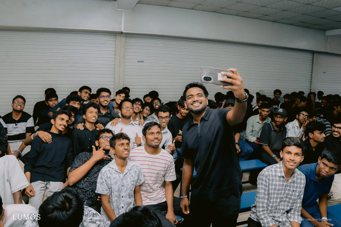 සෙල්ෆි ඡායාරූපයක්, පසුබිමේ විශාල සිසු සමූහයක්